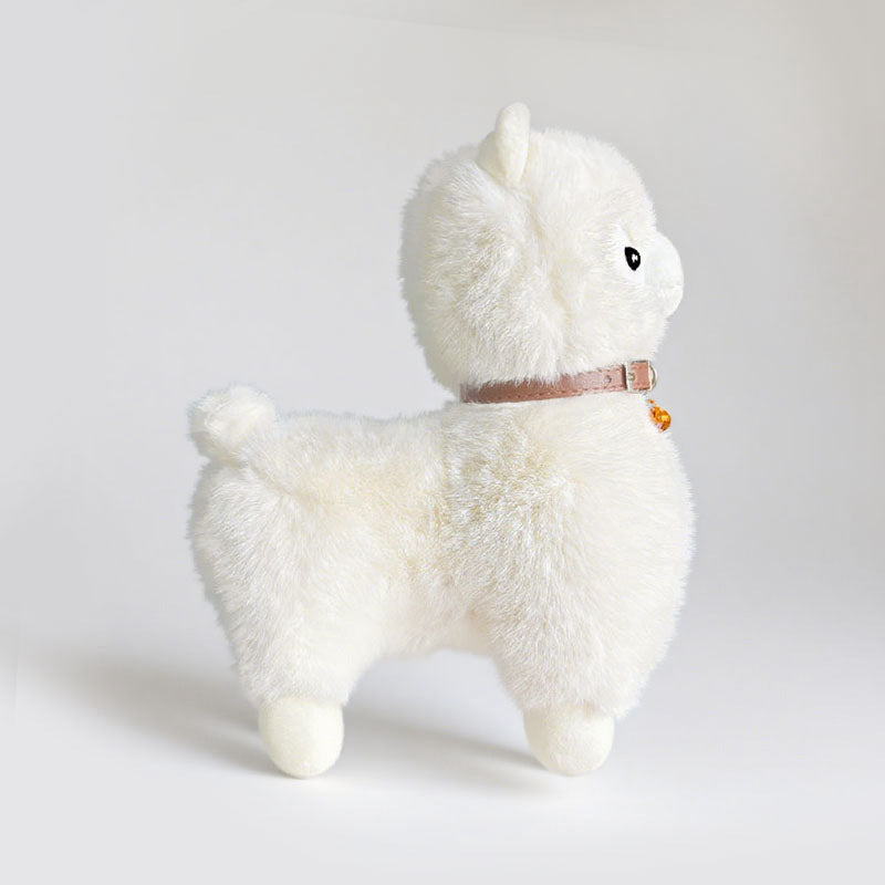 The ZoDoll Cute Alpaca Plush Doll stands upright, facing right, wearing a brown collar with a small bell, shown against a plain light background.