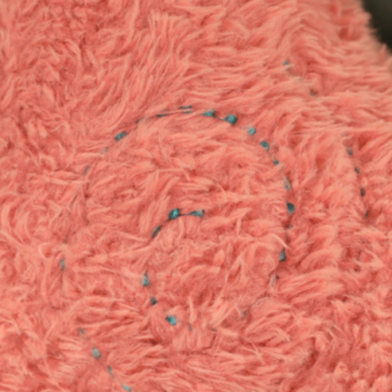 Close-up of the pink textured fabric from the ZoDoll Cute Alpaca Plush Doll - Soft Alpaca Plush Toy 26cm, highlighting its blue embroidered swirl pattern.