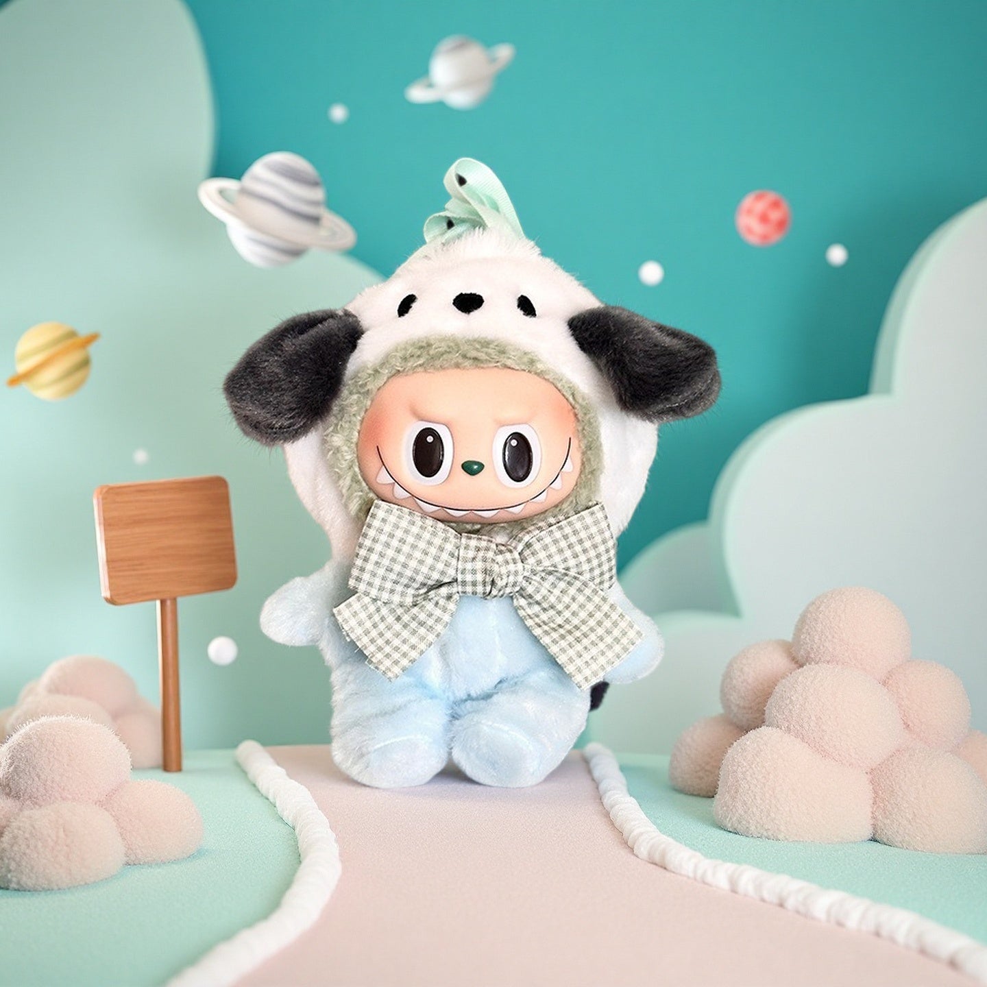 The ZoDoll Labubu Doll wears a white puppy hoodie set with a baby blue plush jumpsuit and gingham bow, standing on a pastel path surrounded by cloud shapes and cartoon planets against a teal background.