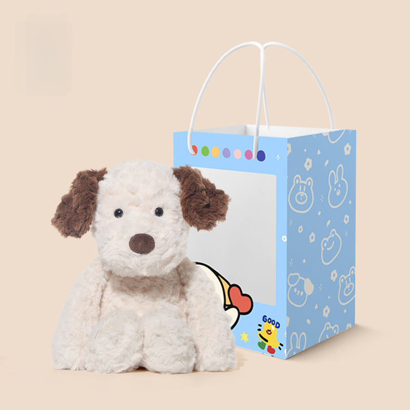 The 35cm JOOKI Plush Puppy Stuffed Toy with soft brown and white fur and floppy ears sits beside a blue gift bag featuring cartoon animal faces and colorful dots on a beige background.
