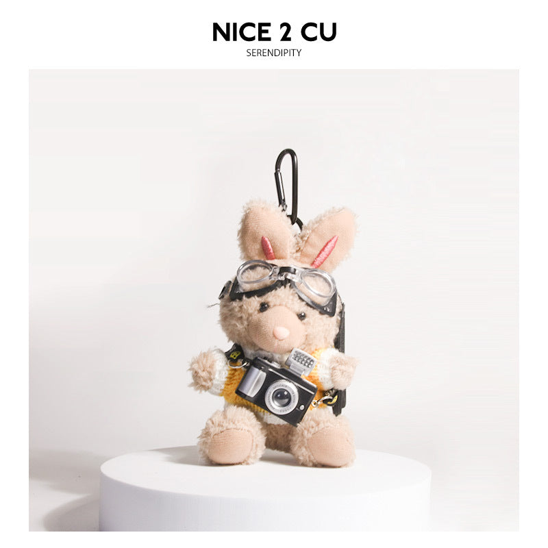 Brown plush rabbit keychain wearing yellow-and-white knit sweater with aviator goggles and camera charm