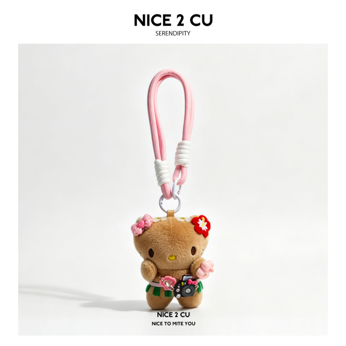 Brown plush character bag charm with flower accessories, tiny camera detail, and pink loop strap