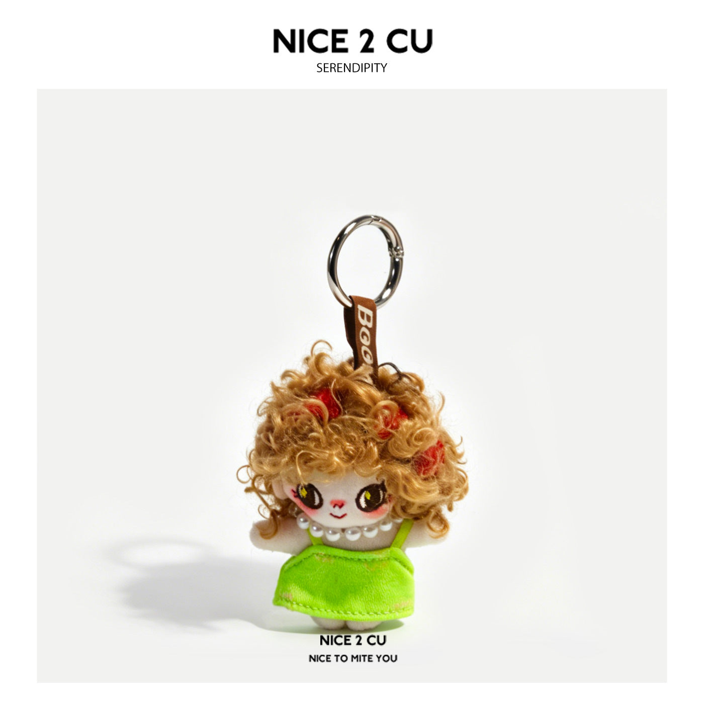 Grumpy girl plush doll keychain charm with curly brown-gold hair and neon green dress on brown woven strap