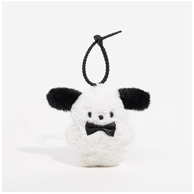 Kawaii plush dog charm with white fluffy body, black floppy ears, and black bow tie, with black hanging loop cord