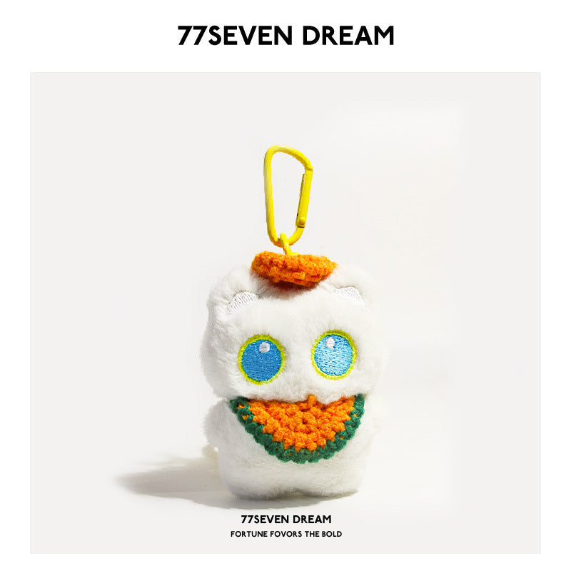 White cat plush charm with blue-outlined eyes and orange crocheted bib with green trim, yellow carabiner
