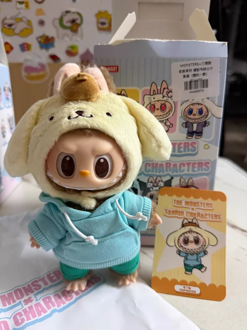 The POP MART LABUBU Hello Kitty and Friends Series Pompompurin Plush Pendant Figure stands before its box and a collector card, featuring a small collectible in character-themed attire.