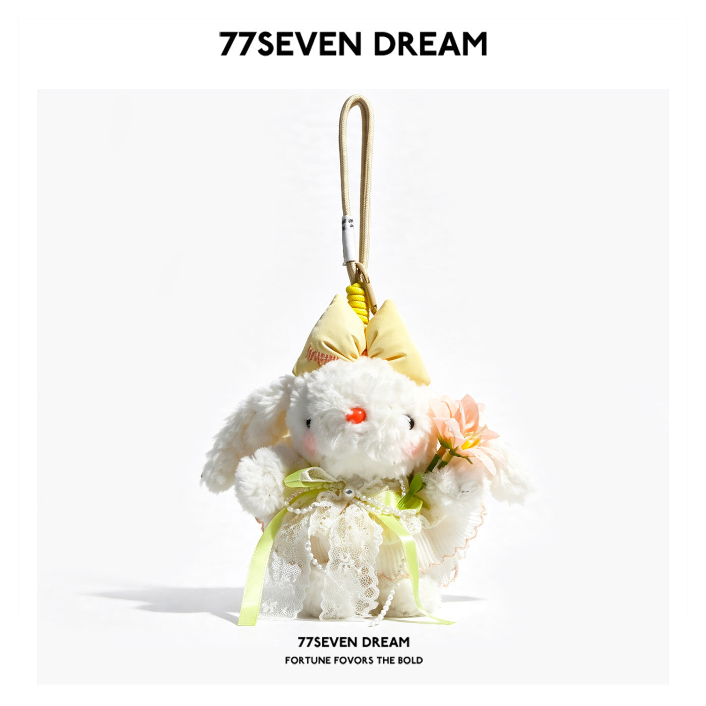 White lop-eared rabbit plush charm in a layered cream and pale yellow floral dress with lace trim and peach flower detail