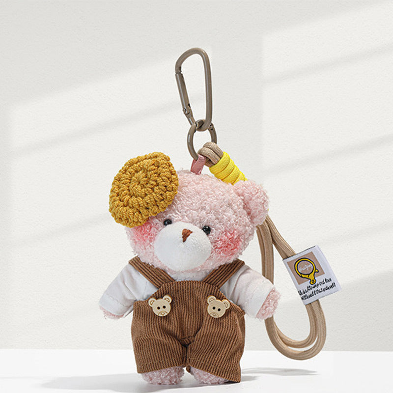 Light pink plush bear charm with brown corduroy overalls, mustard-yellow beret accent, and beige carabiner clip