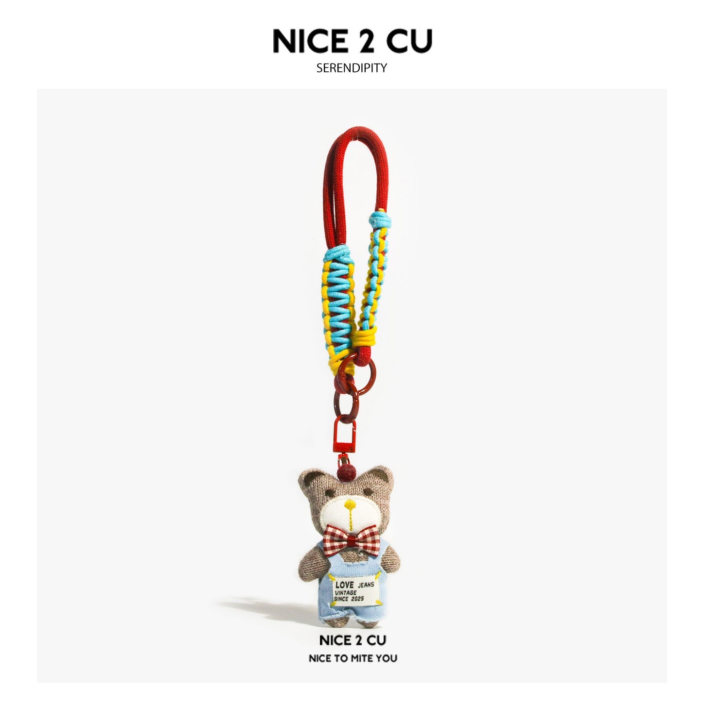 Brown plush bear charm in denim overalls with red plaid bow tie hanging from a multicolored braided cord keychain