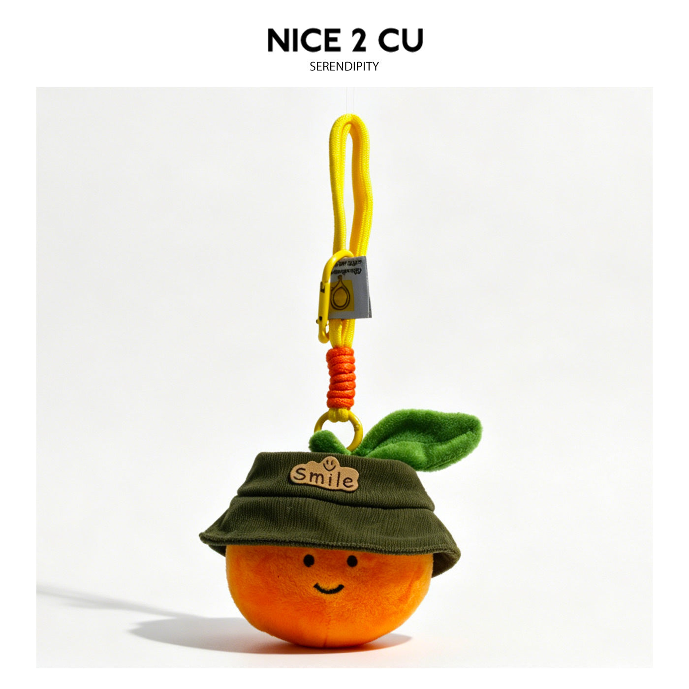 Smiling orange plush charm wearing a dark green bucket hat with a Smile patch and green leaf detail on a yellow hanging strap