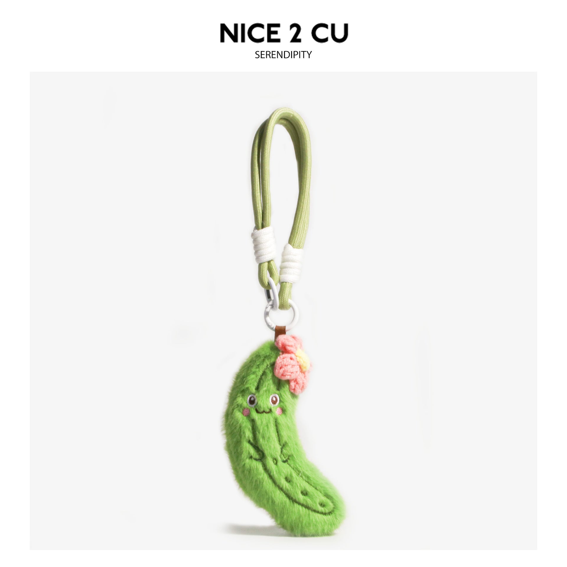 Cute cucumber plush keychain charm with pink crocheted flower and embroidered smiling face