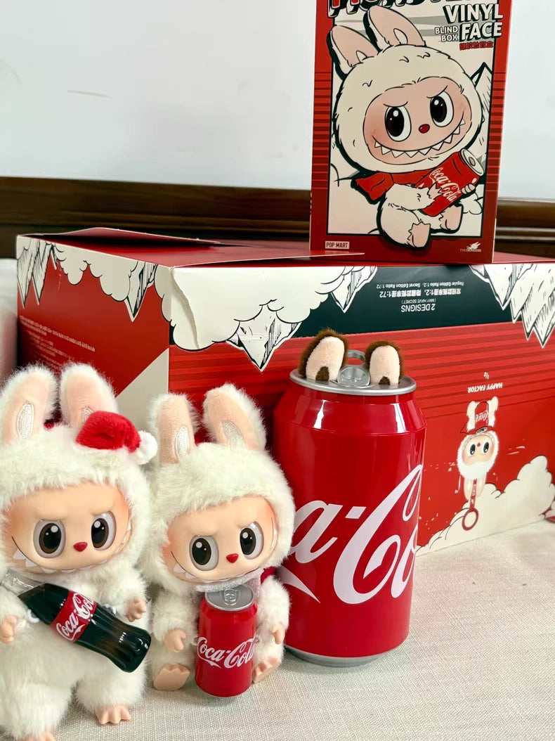 Two POP MART Labubu Coca-Cola Surprise Shake Plush Keychains – Christmas Bunny Edition are displayed with themed packaging, a large Coca-Cola can, and a cartoon rabbit backdrop.