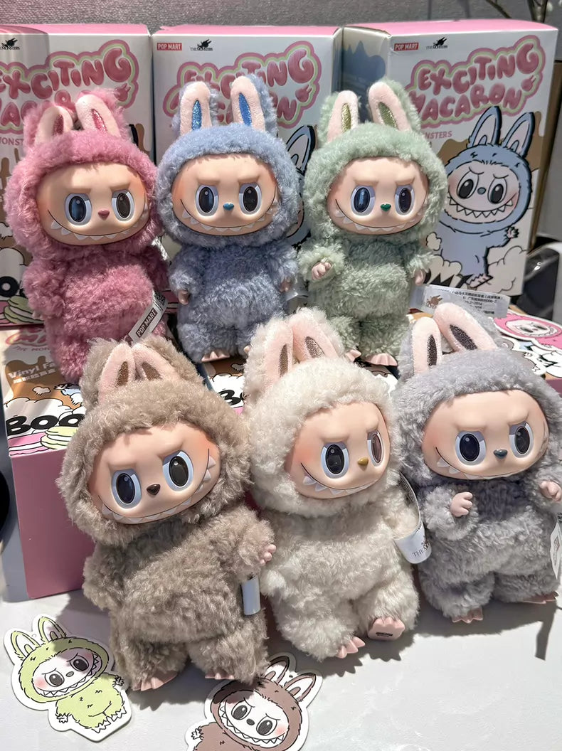 Six plush keychains with vinyl faces and bunny ears, from the POP MART Labubu The Monsters “Exciting Macaron” limited 6-piece set, are displayed—an exclusive collectible for fans and collectors.