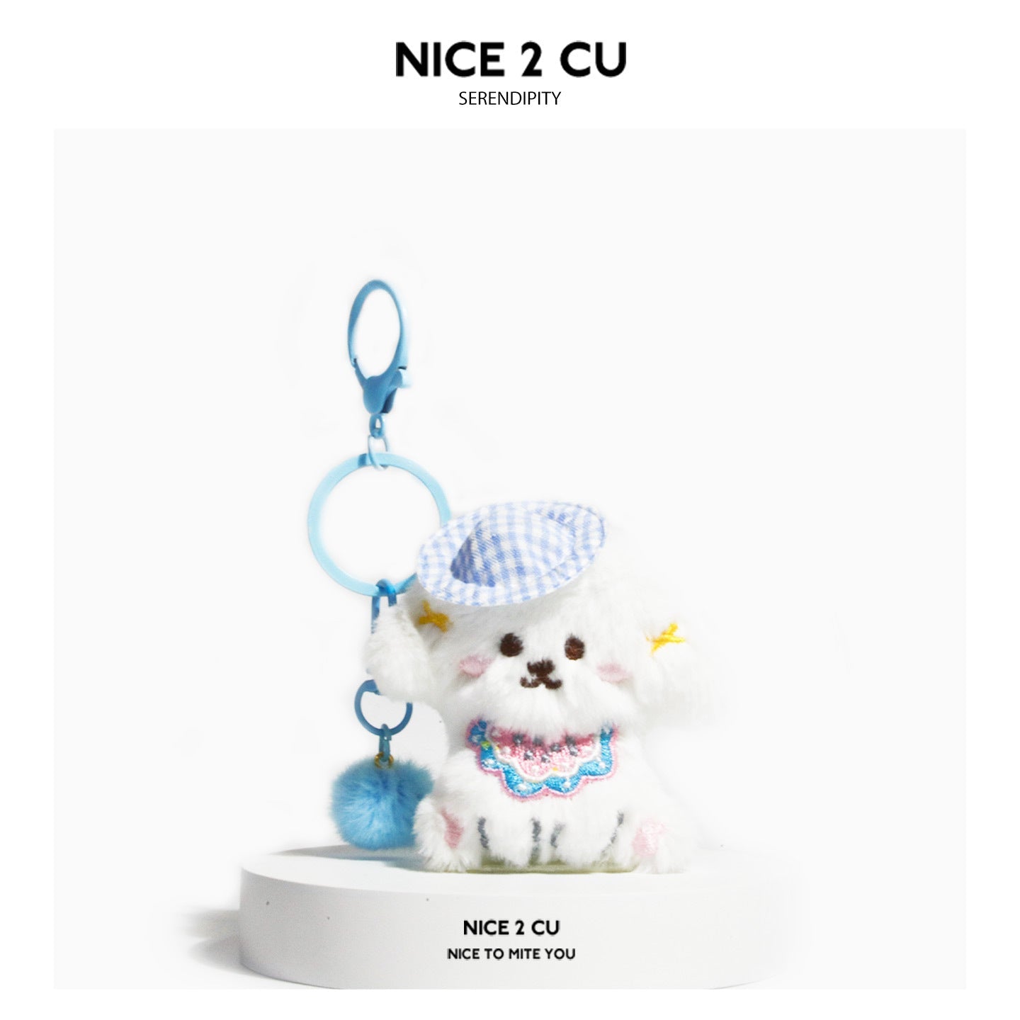 White plush dog keychain charm with light blue checkered cap, blue hardware, and colorful embroidered chest panel