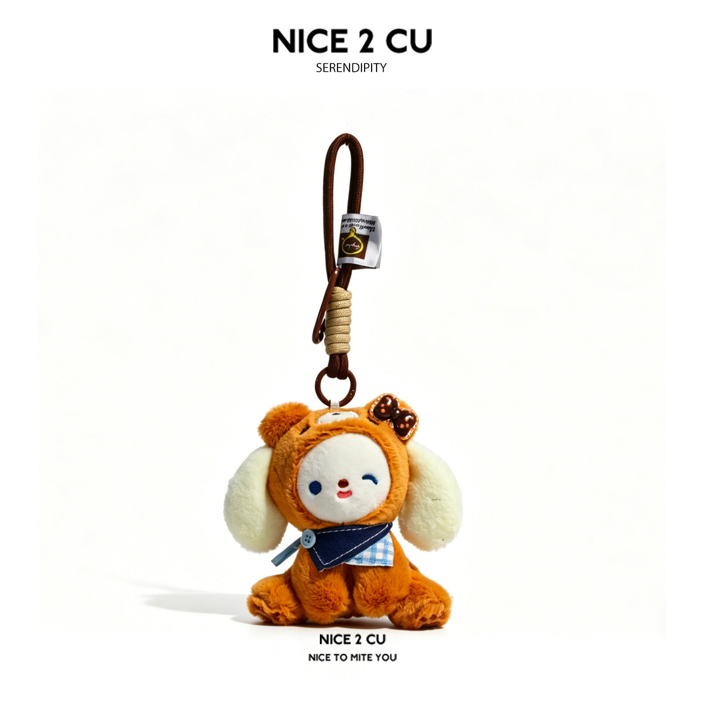 Brown kawaii milk dog plush bag charm with navy knit bib and cream floppy ears on a brown braided cord loop