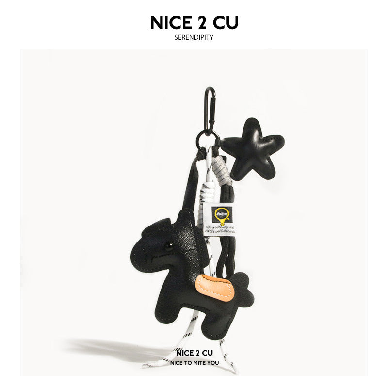 Black leather-look pony and star charm keychain with white cord and beige saddle accent
