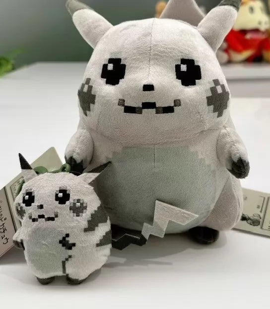 Two gray Retro 8-Bit Pikachu of Beginnings Plush toys by ZoDoll, featuring pixelated faces for Pokémon’s 30th Anniversary, are styled after classic chunky Pikachu and displayed on a white surface.