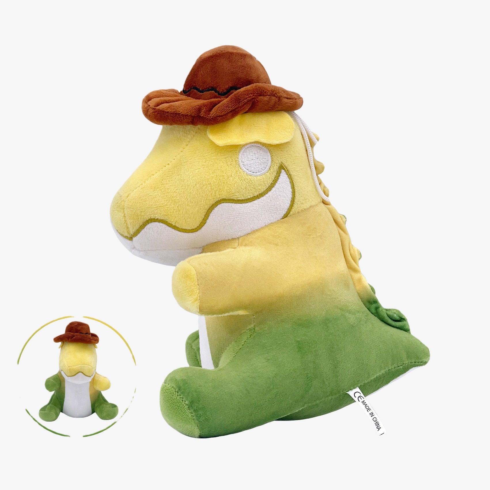 The Amazing Digital Circus Inspired Plush Toy is a 9.8-inch soft stuffed yellow and green dinosaur character doll with a hat, shown in side view with a front view inset at the bottom left.