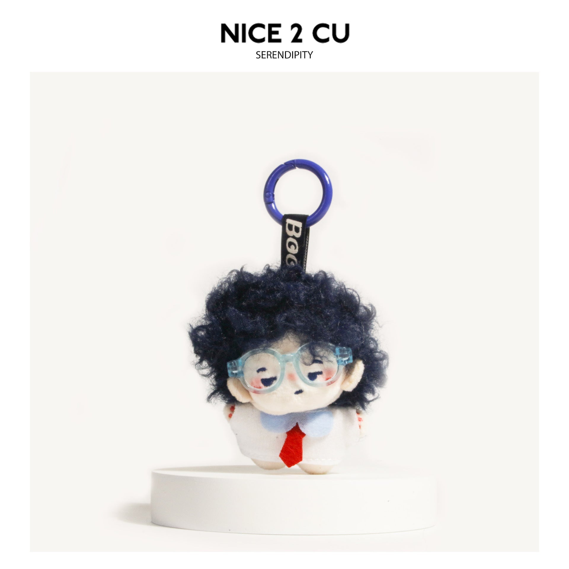 Black curly-haired chibi plush doll keychain with light blue glasses and white outfit on blue carabiner ring