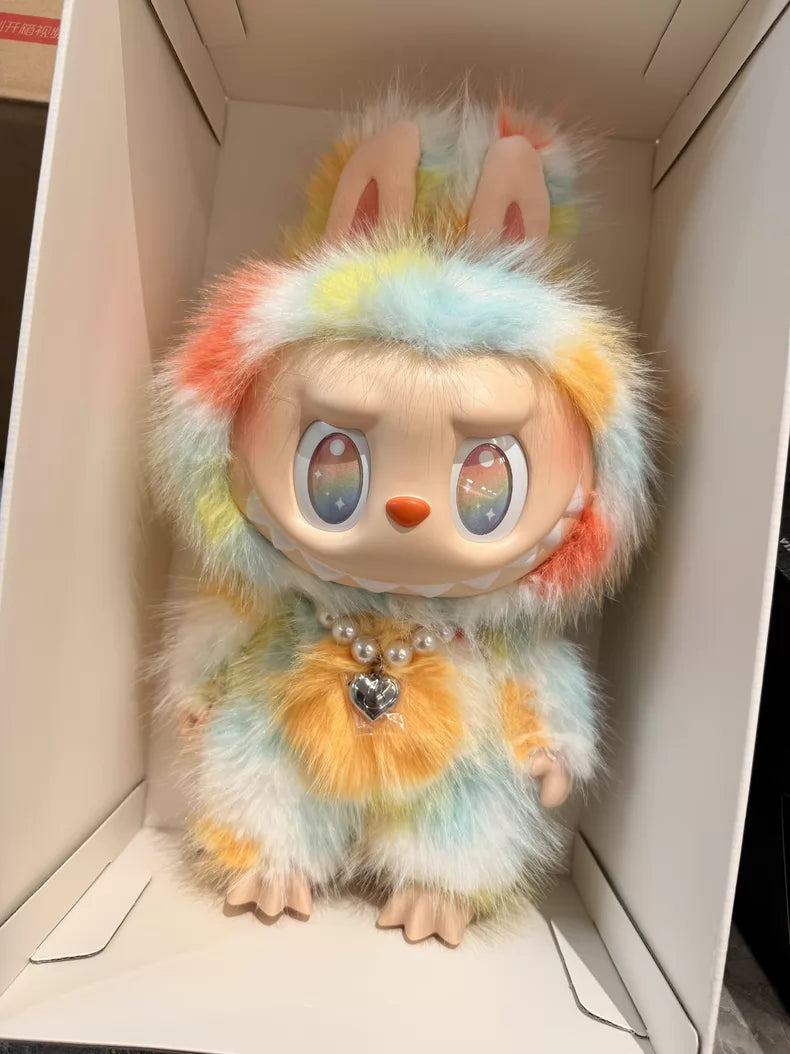 The POP MART Labubu Big into Energy Series Plush Doll (37cm) features large eyes, pastel rainbow fur, rabbit ears, and a pearl necklace with a heart pendant, all in a white display box—a true designer collectible.