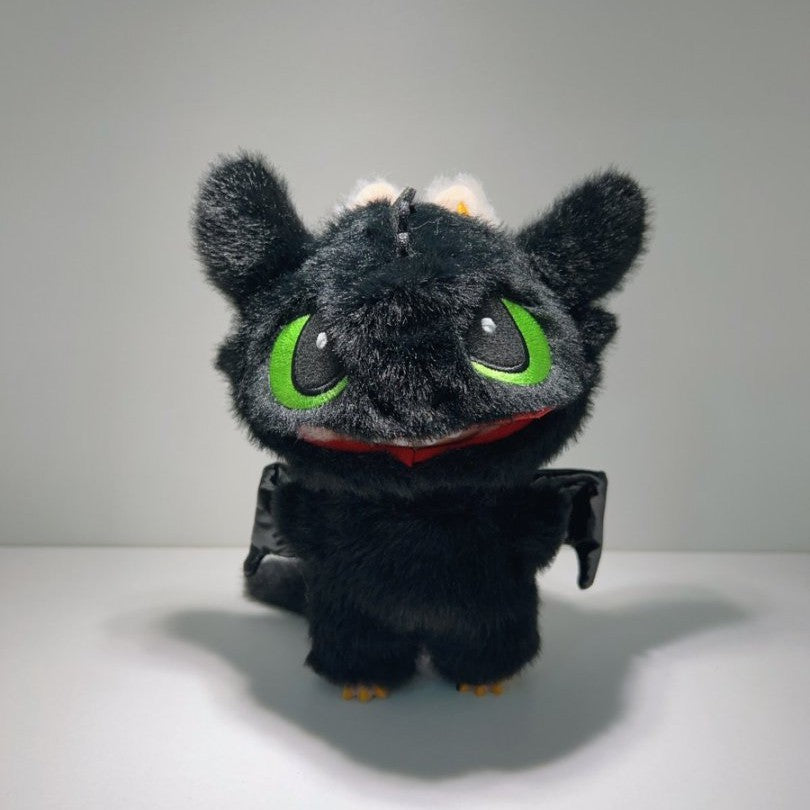 The ZoDoll Labubu Night Fury Dragon Black Plush Full-Body Costume Outfit features a plush toy dragon with black fur, large green eyes, and small wings, standing upright against a plain background.