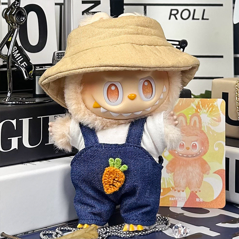 The ZoDoll Labubu Denim Overalls Set features a plush toy with large eyes, sharp teeth, and a beige bucket hat. Dressed in denim overalls with a crochet carrot patch, it stands next to an illustrated card of the character.