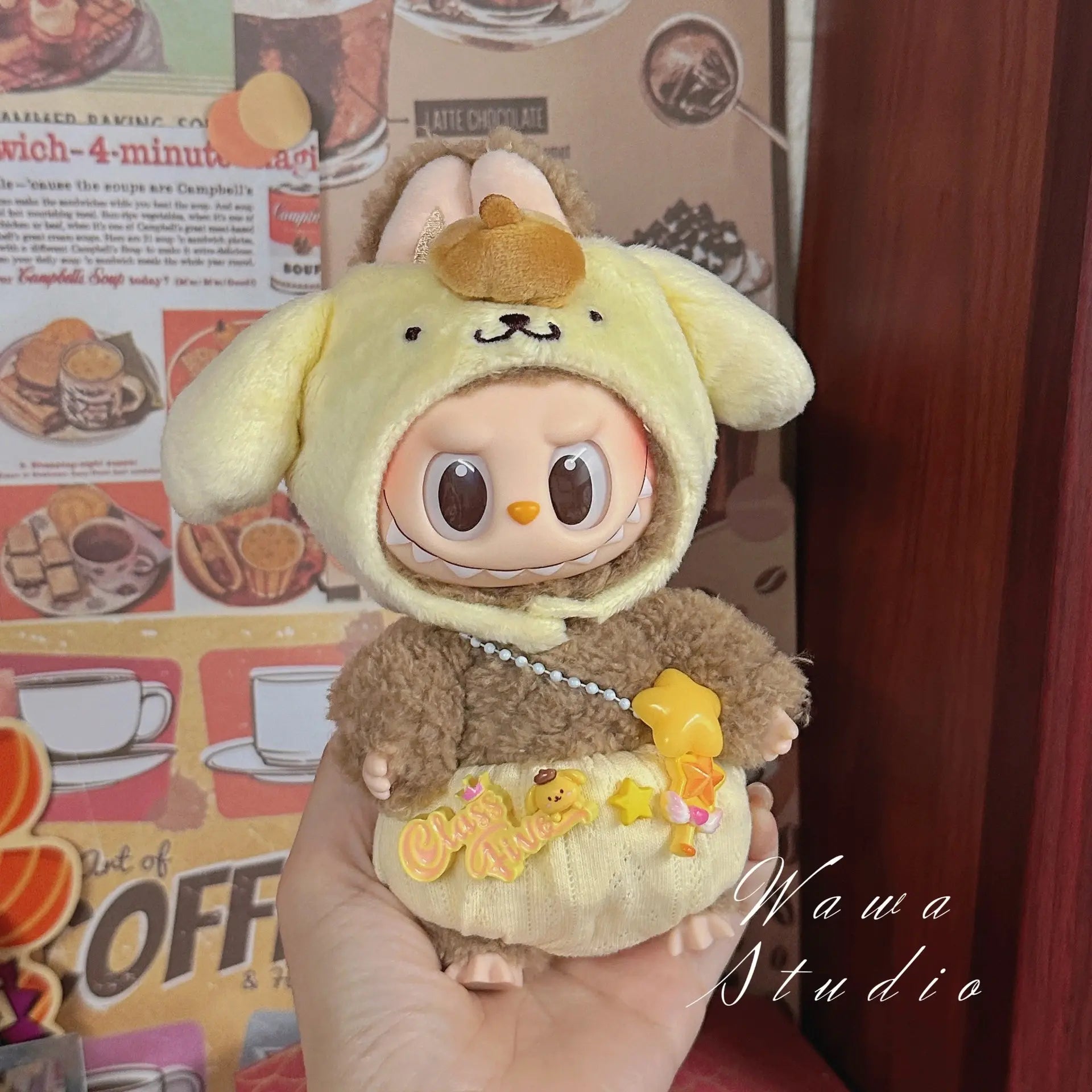 A ZoDoll Labubu Sanrio Doll wears a Hello Kitty style outfit from the Doll Clothes Set collection, displayed in front of a cafe-themed backdrop.