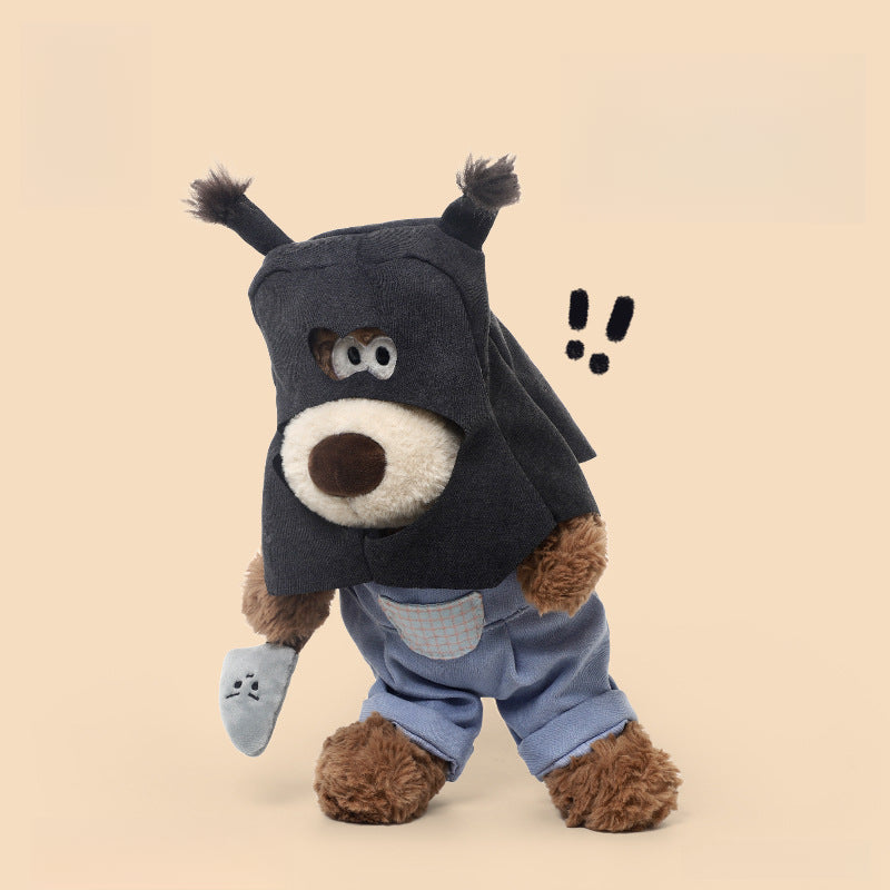The JOOKI 40cm Funny Robber Dog Plush Toy is a dressed-up stuffed puppy with a mask and outfit, posed against a beige background and holding a small grey object marked with two exclamation points near its head.