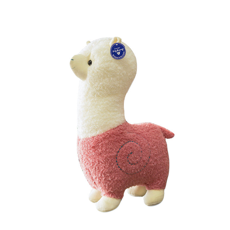The ZoDoll Cute Alpaca Plush Doll is a 26cm soft toy with a white head and neck, pink textured body, four legs, and a blue tag on its ear.