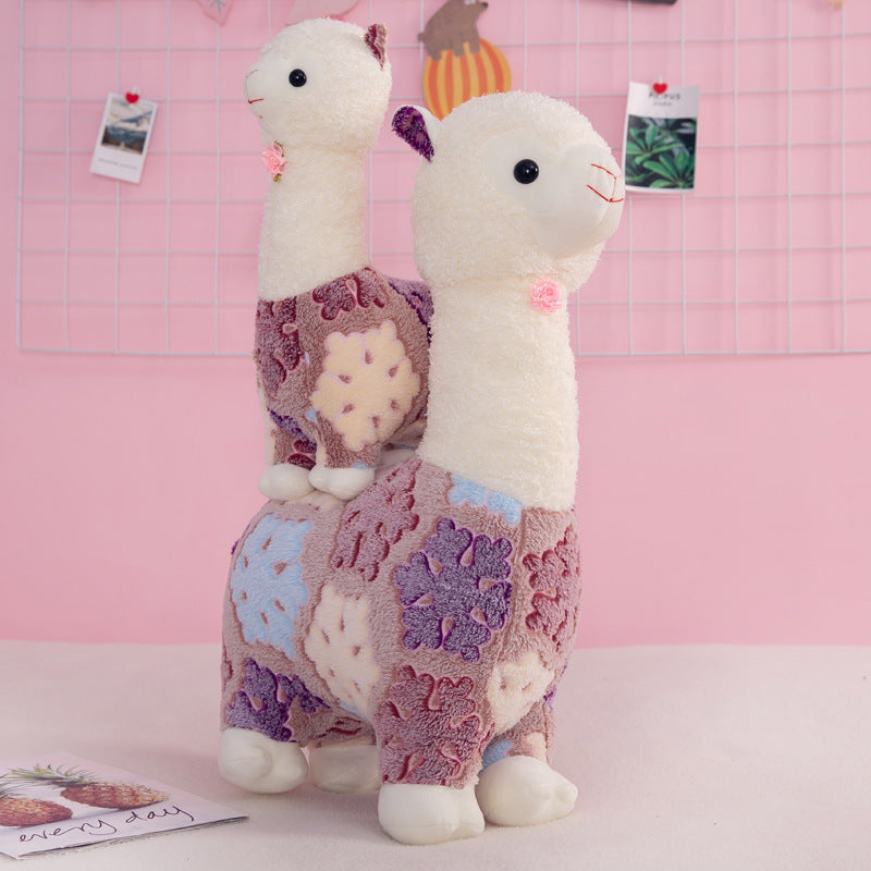 The ZoDoll Flower Alpaca Plush Toy features two soft, patchwork alpaca dolls in purple, cream, and pink—perfect for adding a whimsical touch to any space. These charming stuffed plush friends are an adorable decor accent.