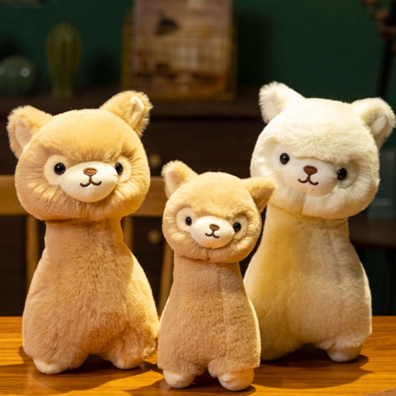 Three ZoDoll Cute Alpaca Plush Dolls—two light brown and one white—stand on a wooden surface with a dark background. These Soft Alpaca Plush Toys come in different sizes.
