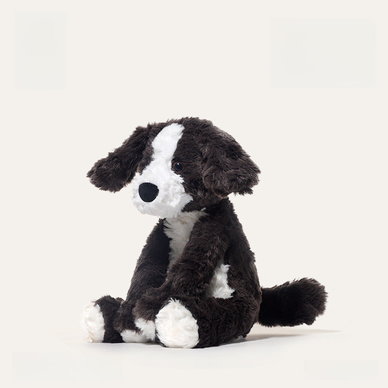 The JOOKI 24cm Black and White Puppy Plush Toy features soft fur and floppy ears, sitting upright against a light background—ideal for cuddles or room decor.