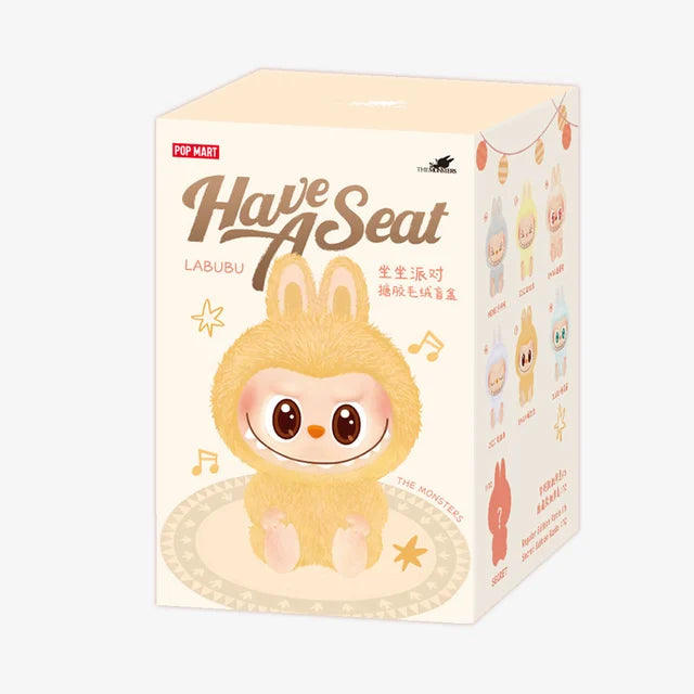A product box for the Labubu “Dada” Plush Keychain – Have a Seat Series Pink Heart-Eye Bunny by POP MART The Monsters, featuring a cartoon bunny, “Have A Seat LABUBU” text, and images of similar POP MART collectibles on the side.
