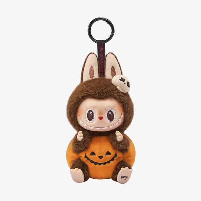 The POP MART THE MONSTERS – Happy Halloween Party Labubu 15cm Vinyl Plush Keychain (Pumpkin Edition) features Labubu in a brown fuzzy animal costume with bunny ears, a skull accent, and an orange pumpkin body—perfect for Halloween!.