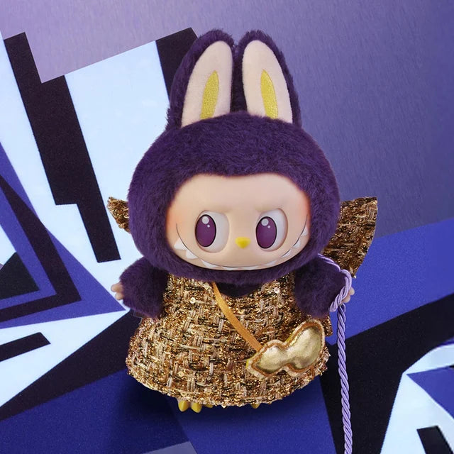 The POP MART Labubu × PRONOUNCE Wings of Fortune Limited Edition Designer Plush Vinyl Toy features large purple rabbit ears, gold wings, and a gold sequined dress against a geometric purple and white backdrop.