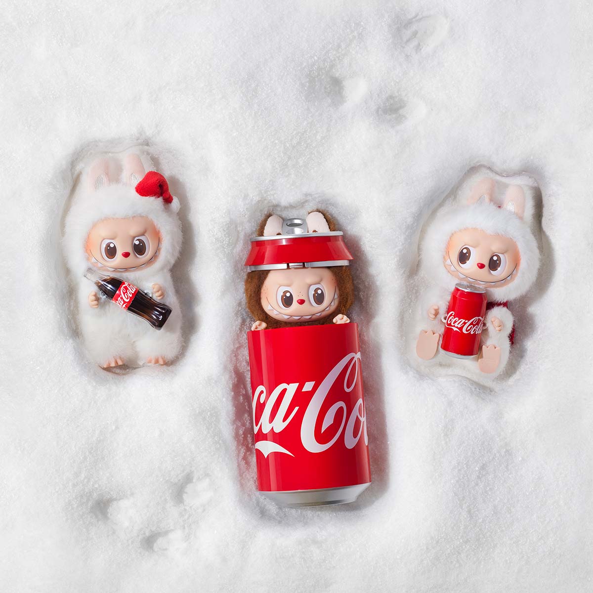 Three POP MART The Monsters appear in white animal outfits on snow; two hold Coca-Cola bottles, while the center Labubu Secret Edition “Mysterious Guest – Coca‑Cola” Plush Keychain emerges from a Coca-Cola can as a rare collectible for fans.