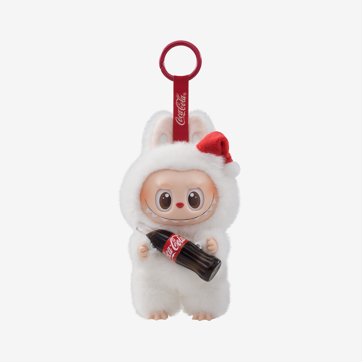 The Labubu Coca-Cola Surprise Shake Plush Keychain – Christmas Bunny Edition Vinyl Collectible by POP MART features Labubu in a white bunny suit with a Santa hat and Coke bottle, perfect as a festive collectible.