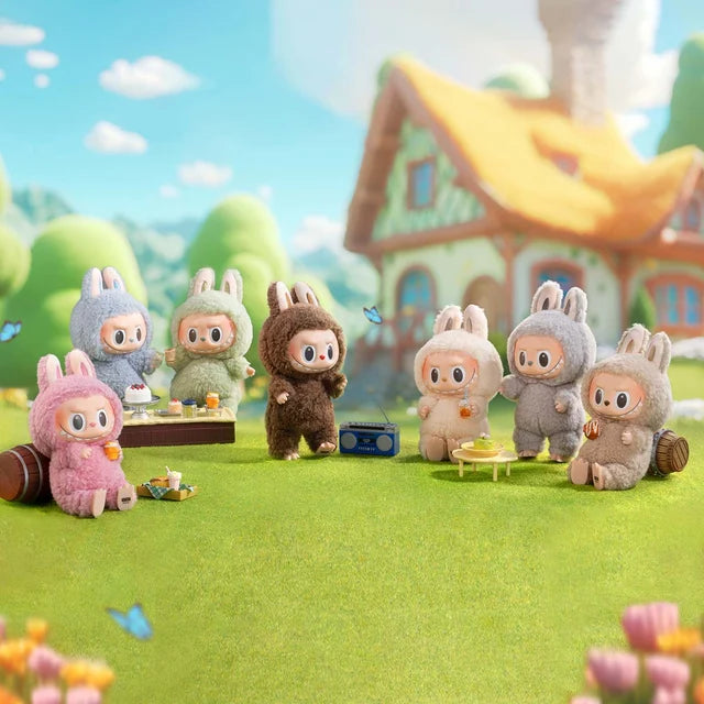 The POP MART Labubu The Monsters “Exciting Macaron” 6-Piece Plush Keychain Set features limited edition bunny dolls by Kasing Lung on a vibrant picnic, surrounded by snacks, drinks, a radio, and a cottage.