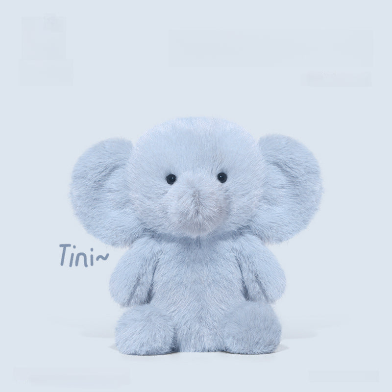 The 23cm Blue Elephant Plush Toy by JOOKI features big ears and a cute face, sitting forward on a light background with “Tini~” written to the left—an adorable gift for babies or fans of stuffed animals.