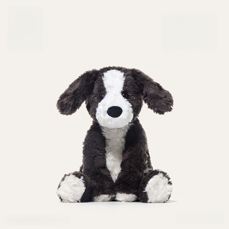 The JOOKI 24cm Black and White Puppy Plush Toy, a soft stuffed dog with floppy ears, is shown sitting upright against a plain white background.