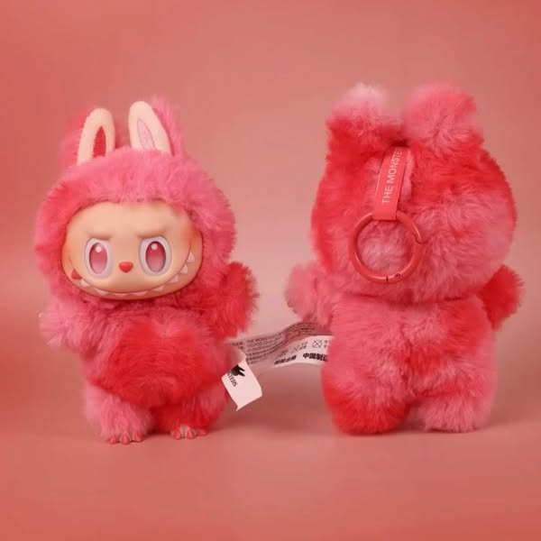 Two Labubu “Love” plush keychains from POP MART’s “Big Into Energy” series are shown in red bunny costumes—one faces forward playfully, while the other reveals a collectible tag and keychain ring.
