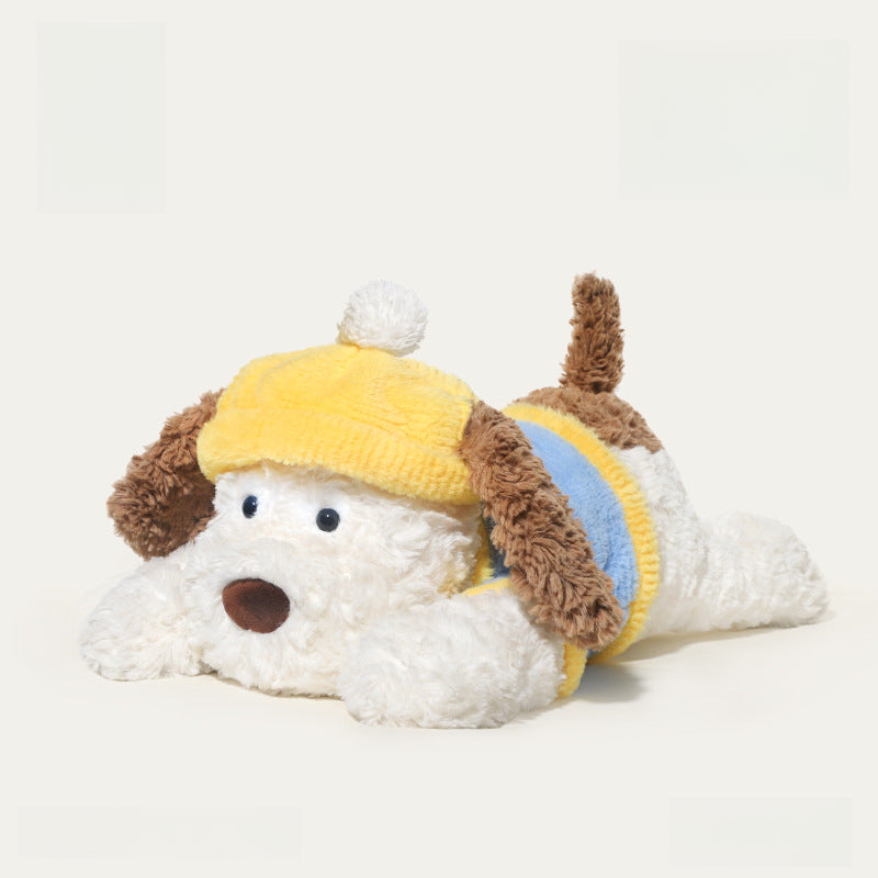 The JOOKI 44cm Lying Dog Plush Toy features a soft, white puppy with floppy brown ears, wearing a yellow hat with pom-pom and a yellow-blue sweater—perfect for kids and decor.