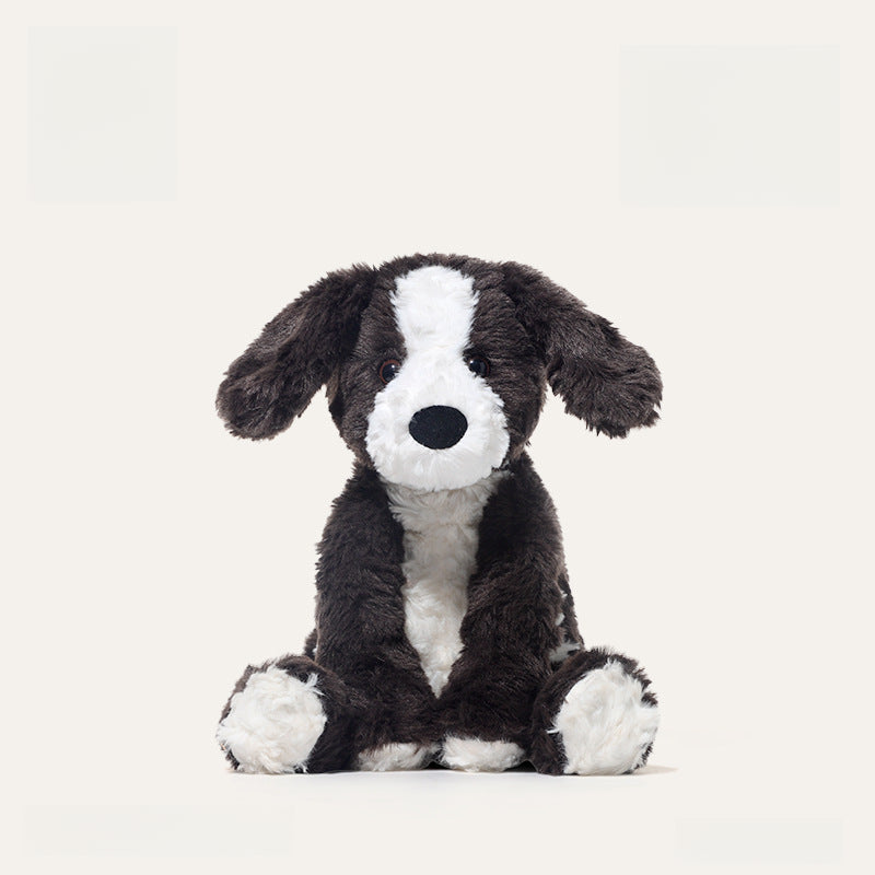 The JOOKI 24cm Black and White Puppy Plush Toy, a soft stuffed dog with floppy ears, sits upright on a plain white background.