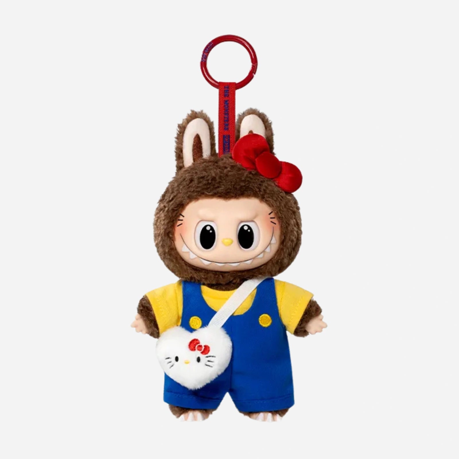 The LABUBU Hello Kitty and Friends Series Secret Edition Plush Pendant Figure by POP MART features a doll in a brown bunny costume, red bow, blue overalls, yellow shirt, and heart-shaped cat purse—a charming collectible keychain.