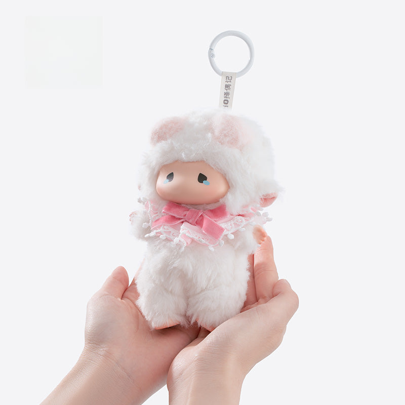 A person holds the ZEIO Sheep Plush Keychain—a 16cm soft, fuzzy lamb doll with a bow and clip—against a plain white background.