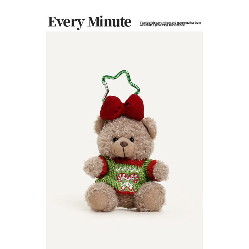 Light-brown curly plush teddy bear keychain wearing a green and red Christmas knitted sweater with candy cane embroidery and 