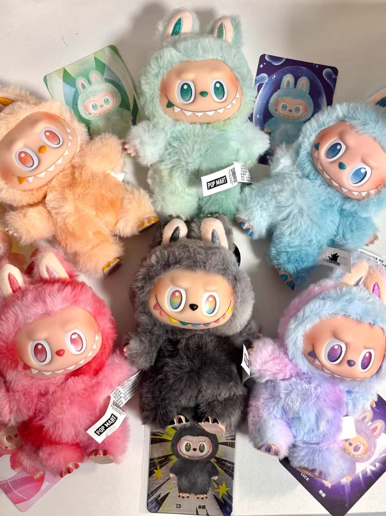 Six Labubu “Big Into Energy” plush keychains by POP MART—Love, Happiness, Loyalty, Serenity, Hope & Luck—are arranged in a circle with their collectible cards from the complete 6-piece set on a white surface.