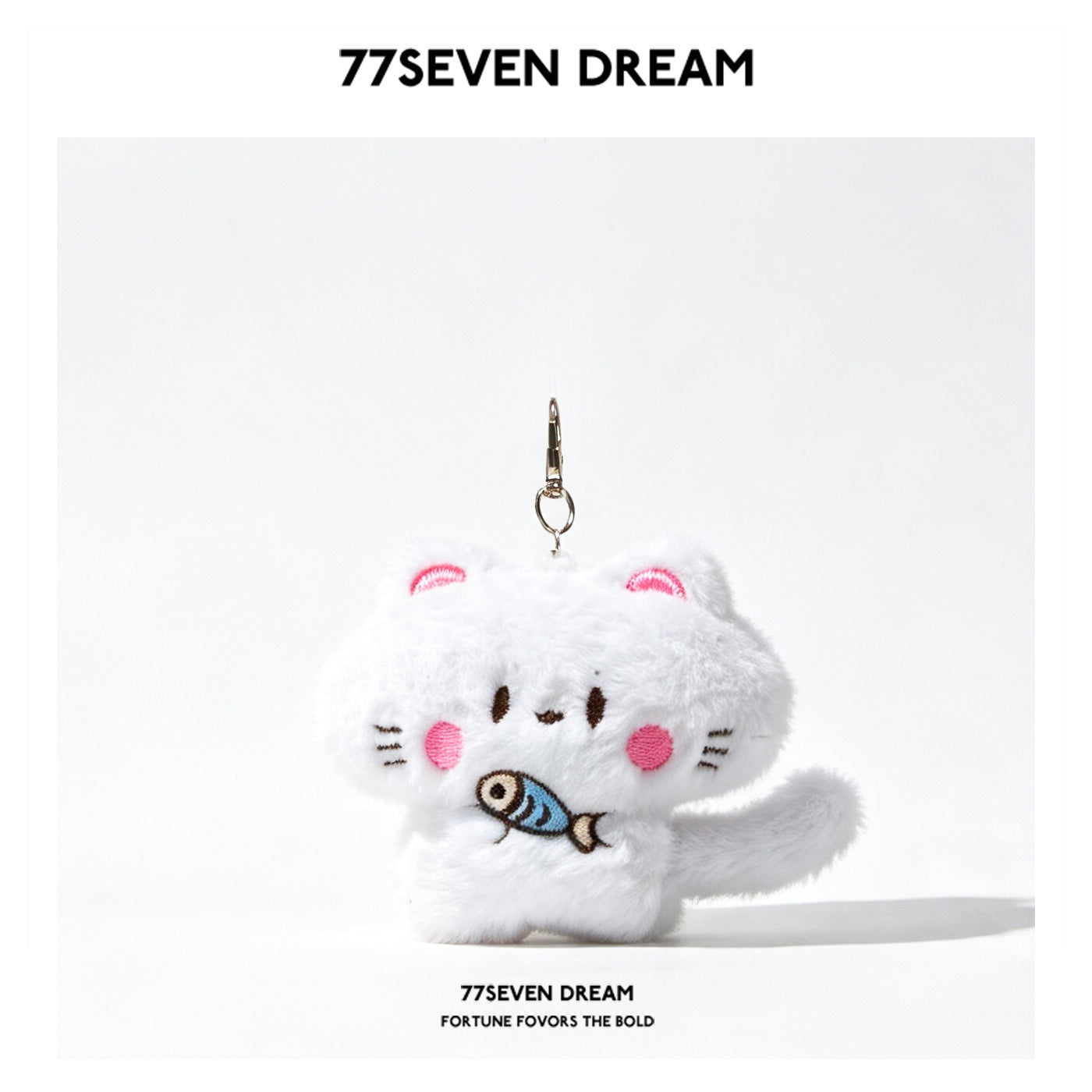 White kawaii cat plush keychain charm holding an embroidered blue fish, with pink cheeks and a silver lobster-claw clasp