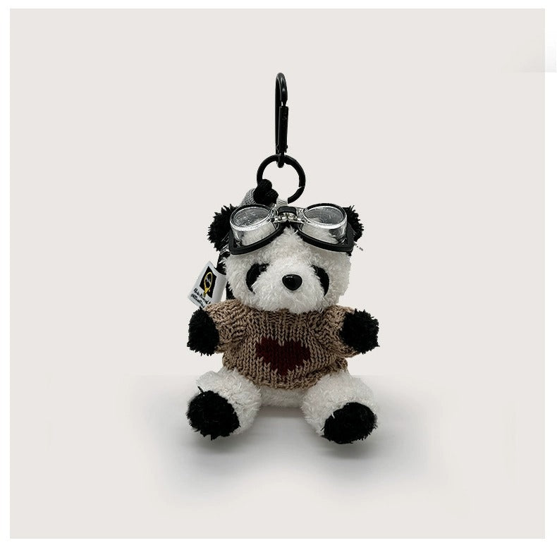 Seated panda bag charm in brown knitted sweater with red heart design and aviator goggles