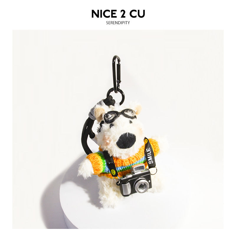 White plush Westie dog keychain wearing a multicolor rainbow striped sweater, goggles, and a miniature camera on a SMILE stra
